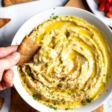 This Extra Garlic Hummus (emphasis on the “EXTRA”) is the perfect snack or appetizer for all our fellow garlic lovers out there! It’s an easy-to-make 10-ingredient dip with a dynamite flavor and silky smooth texture that will not disappoint. #vegan #vegansnack #veganappetizer #plantbased #hummus #hummusrecipe #garlic #garlicrecipe