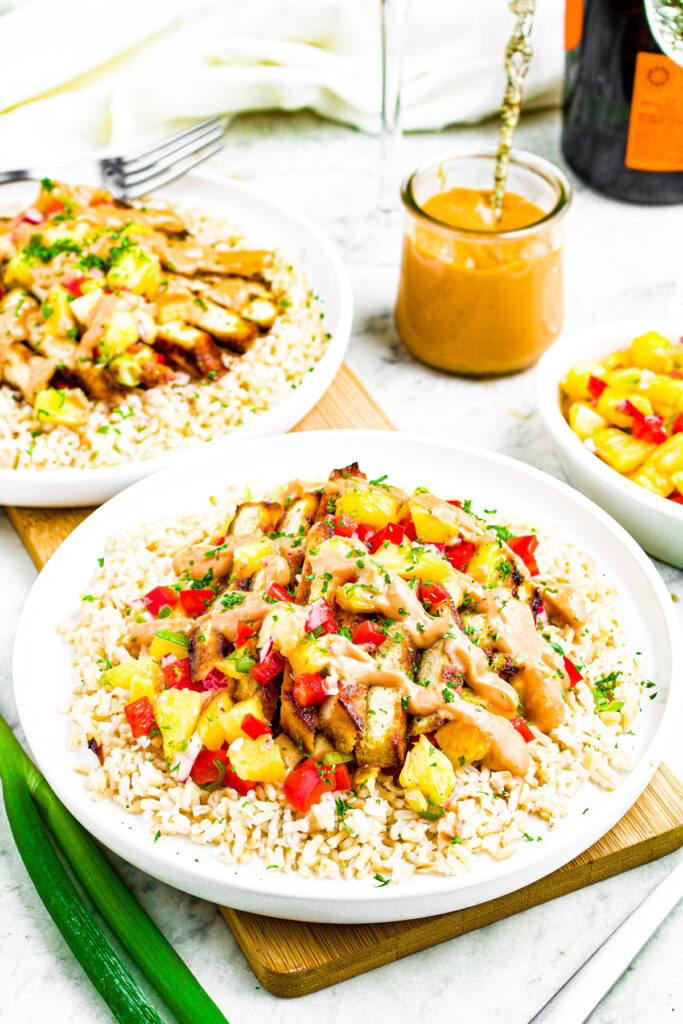 Overhead photo of a plate of pineapple tofu with rice, pineapple salsa, and spicy teriyaki mayo. There's a jar of teriyaki mayo behind the plate