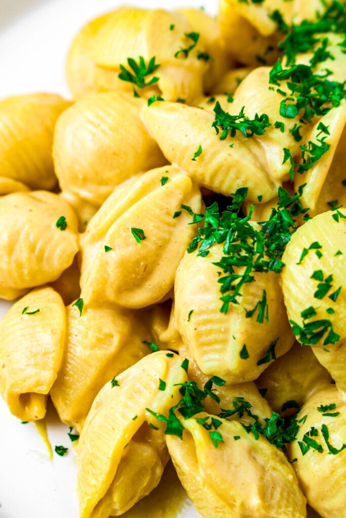 Close up shot of a pile of silken tofu mac and cheese sprinkled with fresh parsley
