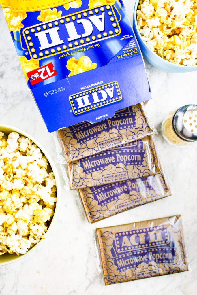 Overhead photo of a box of microwave popcorn with 4 individually wrapped bags of popcorn spilling out of it