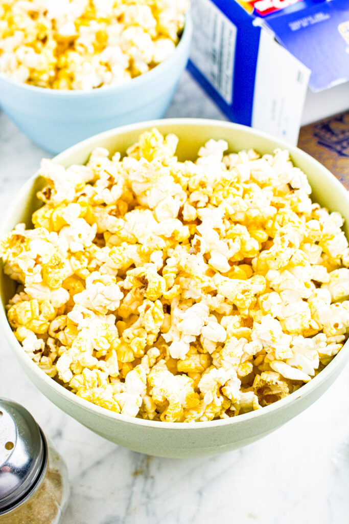 Overhead photo of a bowl of popcorn with another one in the distance
